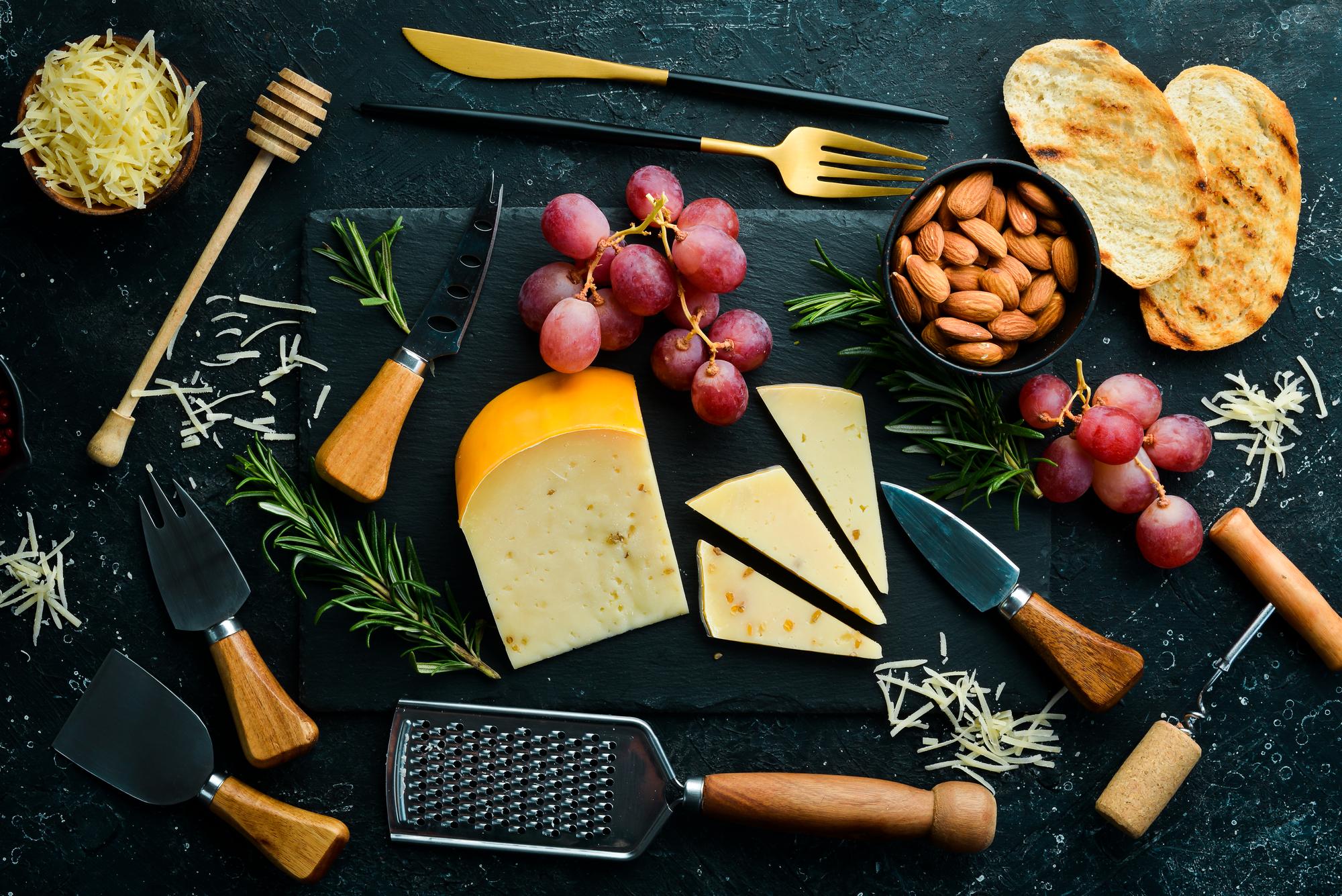 Overhead of curated tasting board with cheeses and garnishes