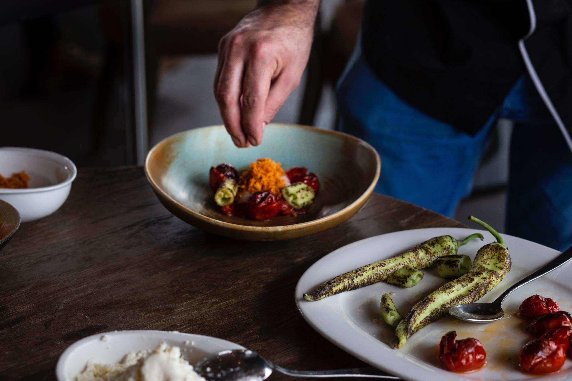 Chef arranging plated dish on wooden table